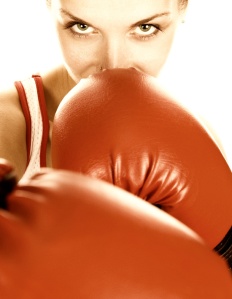 Sepia toned portrait of a girl with red boxing gloves